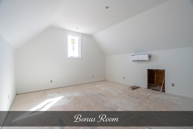 additional living space with vaulted ceiling and a wall unit AC