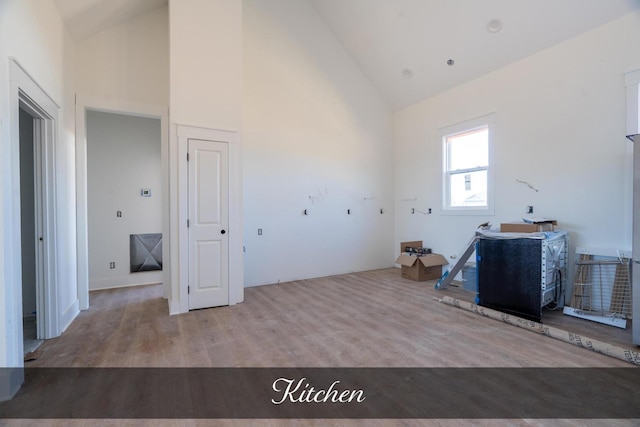 washroom with a towering ceiling and wood finished floors