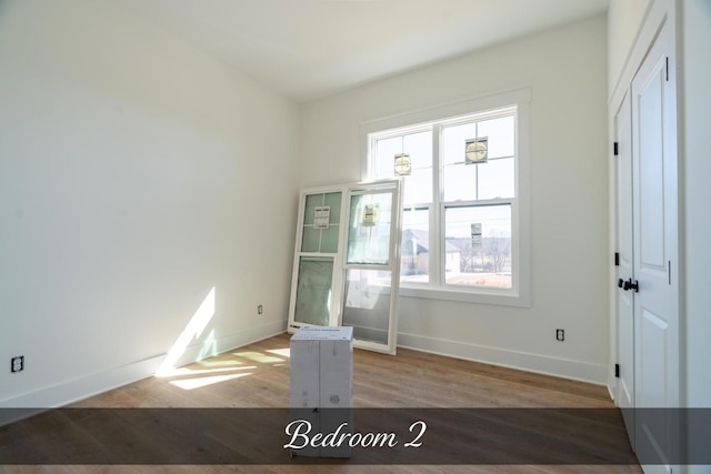 unfurnished room with baseboards and wood finished floors