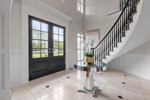 foyer entrance with plenty of natural light, a decorative wall, and tile patterned floors