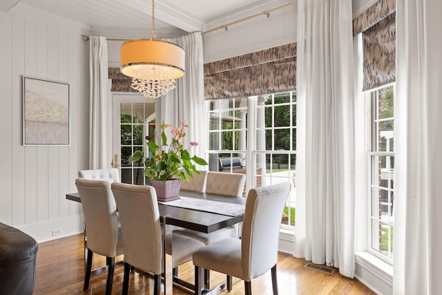 dining area featuring a notable chandelier, beam ceiling, visible vents, and wood finished floors