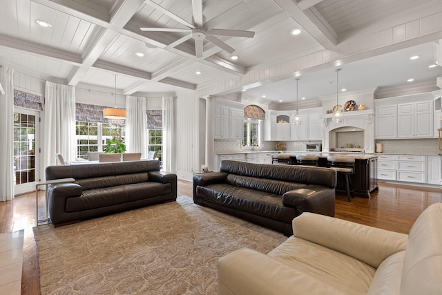 living area featuring ceiling fan, coffered ceiling, beamed ceiling, and wood finished floors