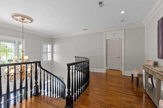 corridor featuring crown molding, a notable chandelier, visible vents, an upstairs landing, and wood finished floors