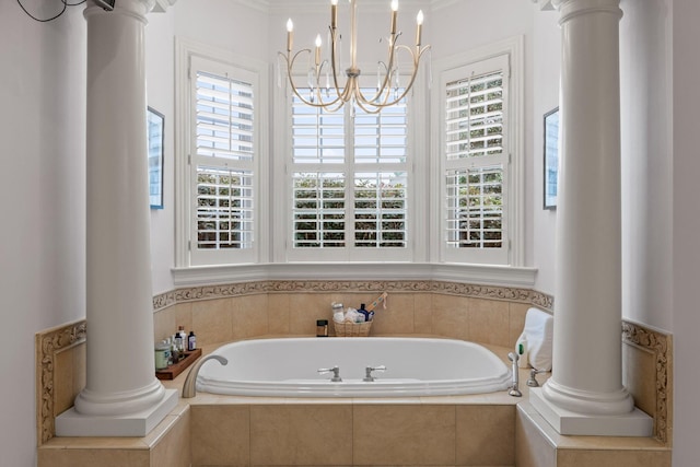 full bathroom with a notable chandelier, decorative columns, and a bath