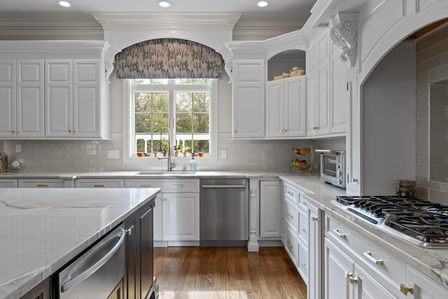 kitchen with appliances with stainless steel finishes, a sink, white cabinetry, and crown molding