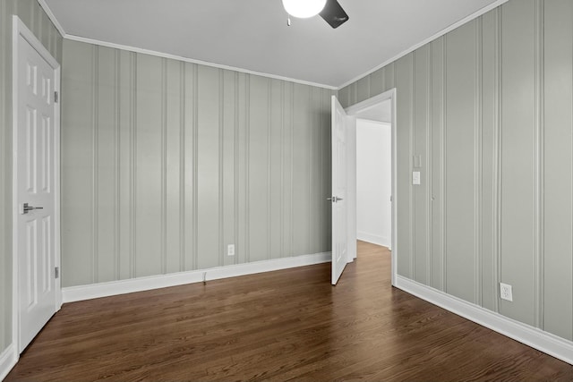 spare room with dark wood-style flooring and crown molding