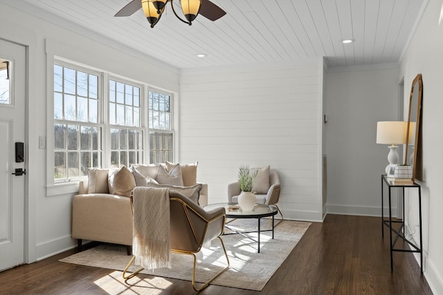 living room with wooden ceiling, crown molding, baseboards, and wood finished floors