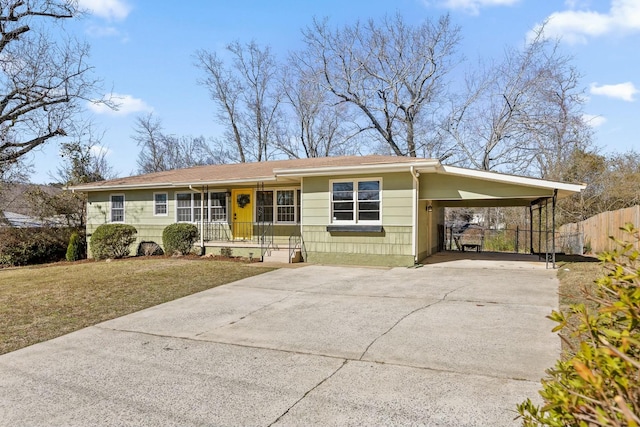 single story home featuring a porch, concrete driveway, fence, a carport, and a front lawn