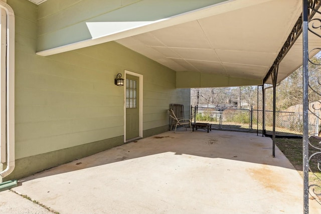 view of patio / terrace with a gate, fence, and a carport