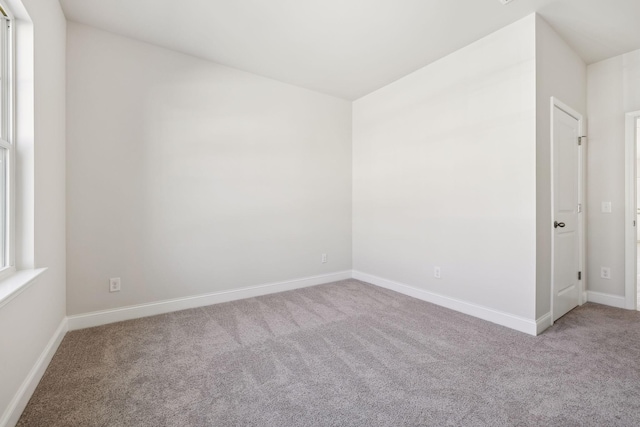 empty room with carpet and baseboards