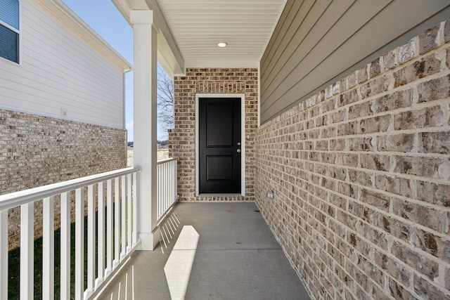 doorway to property featuring brick siding