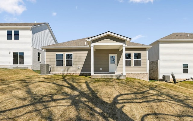 back of house featuring central air condition unit and a yard