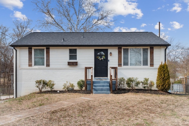 view of front of home with brick siding and a shingled roof