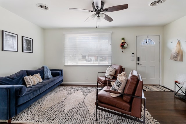 living area with ceiling fan, visible vents, and wood finished floors