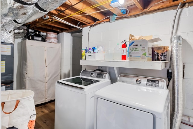 washroom featuring wood finished floors, laundry area, and separate washer and dryer