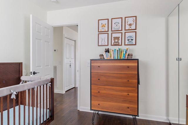 bedroom with wood finished floors, visible vents, and baseboards