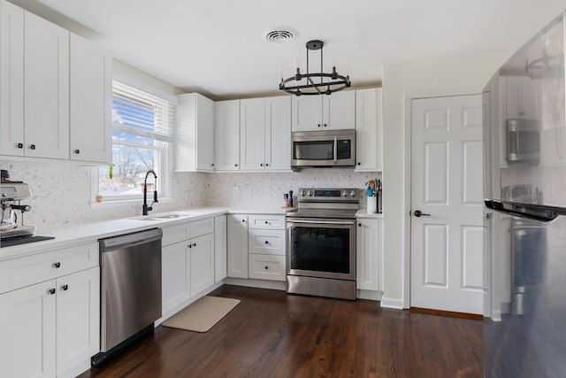 kitchen with light countertops, visible vents, appliances with stainless steel finishes, dark wood-type flooring, and a sink