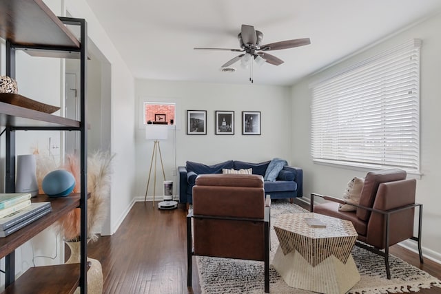 living room featuring baseboards, a ceiling fan, and wood finished floors