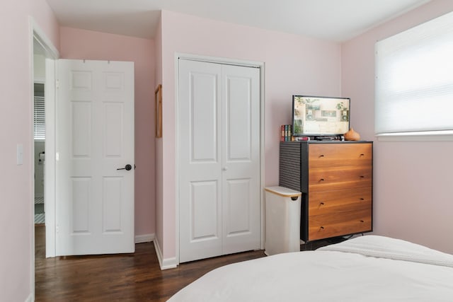 bedroom featuring dark wood-style floors, a closet, and baseboards