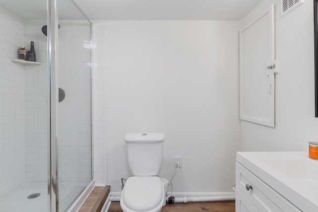 bathroom with visible vents, baseboards, toilet, wood finished floors, and a shower stall