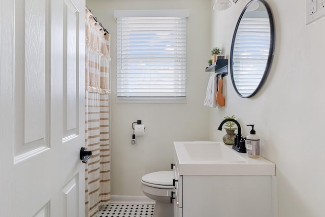 bathroom featuring toilet, curtained shower, baseboards, and vanity