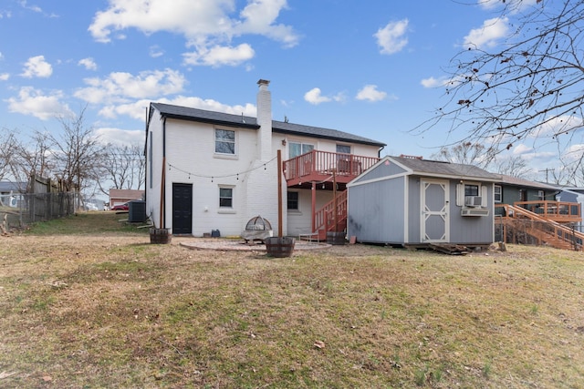 back of house with a lawn, a chimney, an outbuilding, a storage unit, and central AC