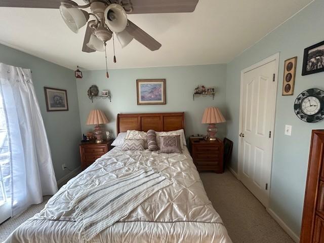 bedroom with baseboards, a ceiling fan, and light colored carpet