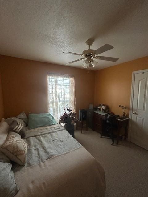 bedroom with light carpet, ceiling fan, and a textured ceiling