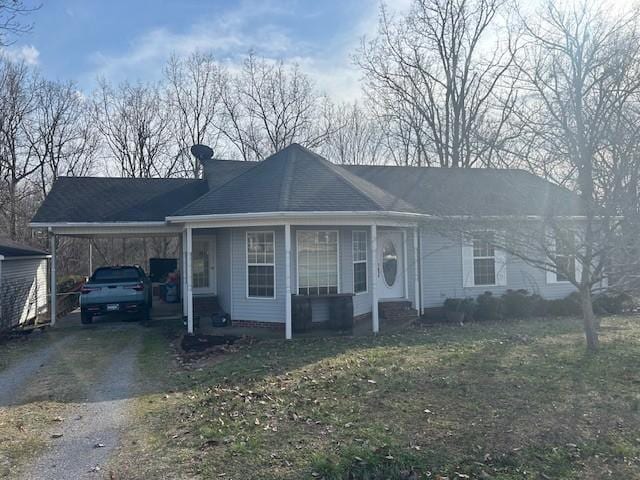 ranch-style house with driveway, an attached carport, and a front yard