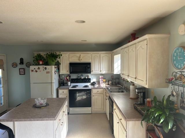 kitchen featuring a kitchen island, a sink, black appliances, and light floors