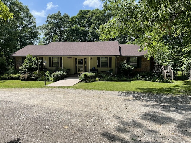 ranch-style house featuring brick siding, driveway, and a front lawn