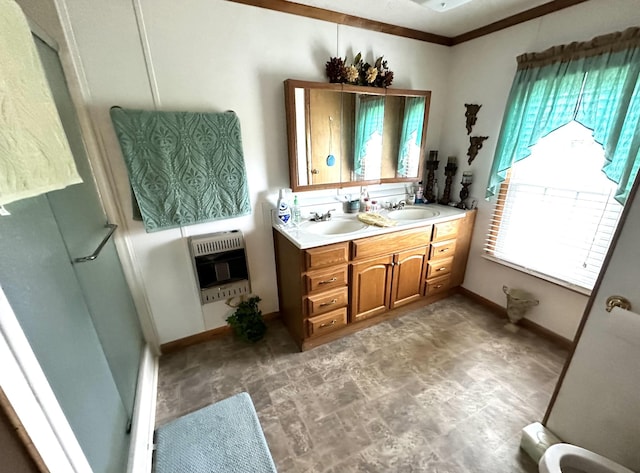 bathroom featuring heating unit, a sink, double vanity, and a wealth of natural light