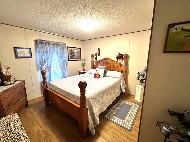 bedroom featuring a textured ceiling and wood finished floors