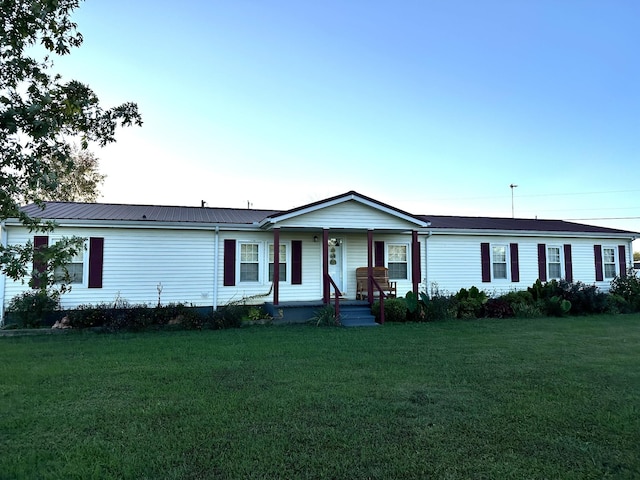 manufactured / mobile home featuring metal roof and a front lawn