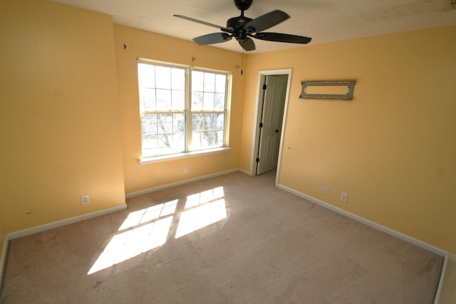 unfurnished room featuring a ceiling fan, baseboards, and carpet flooring