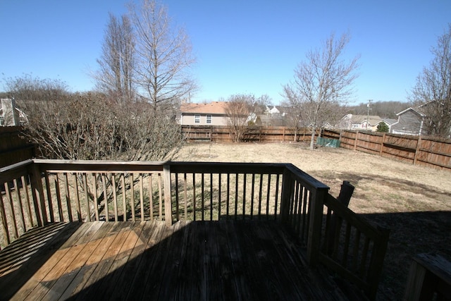 wooden terrace with a fenced backyard