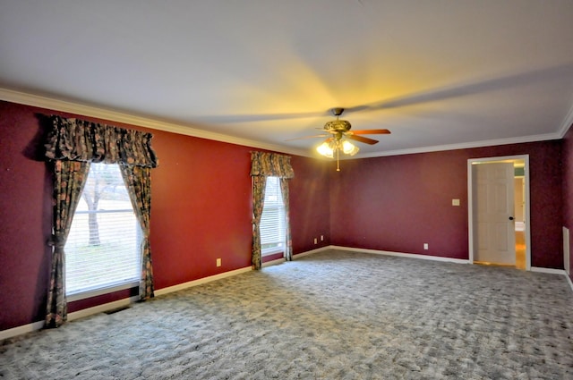 spare room with carpet floors, ceiling fan, baseboards, and crown molding