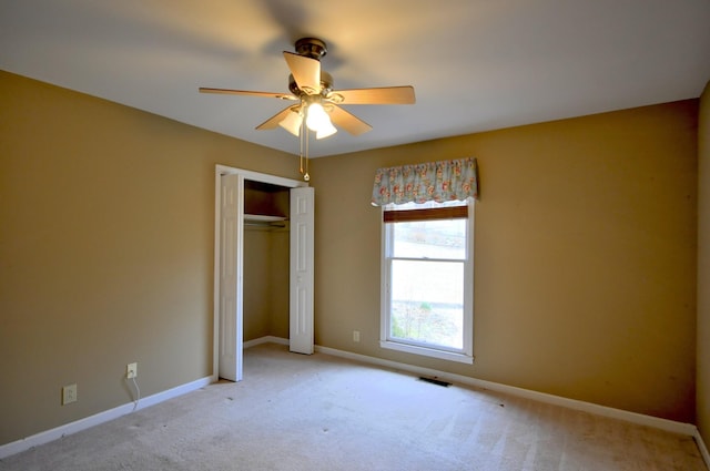 unfurnished bedroom featuring light carpet, baseboards, visible vents, ceiling fan, and a closet