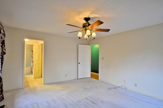 empty room featuring ceiling fan, baseboards, and a textured ceiling