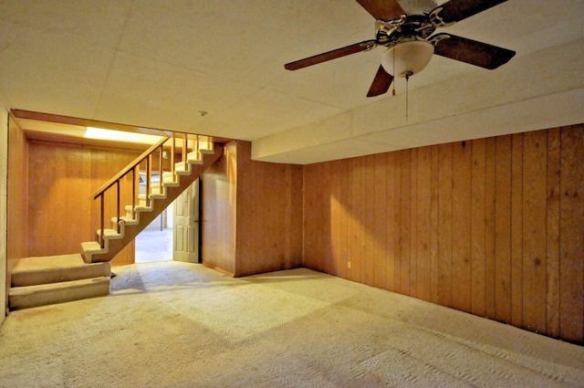 finished basement featuring carpet floors, stairway, and wooden walls