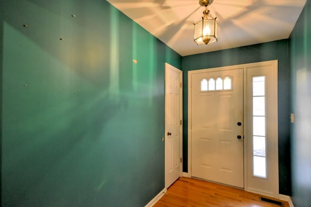 entryway with light wood-style flooring, visible vents, and baseboards