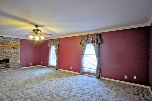 unfurnished living room with a wealth of natural light, a fireplace, ornamental molding, and carpet flooring