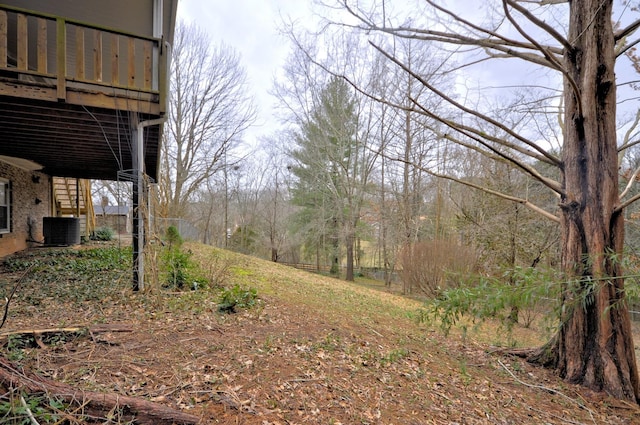 view of yard with central AC unit and a wooden deck