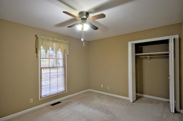 unfurnished bedroom featuring light carpet, baseboards, visible vents, a ceiling fan, and a closet