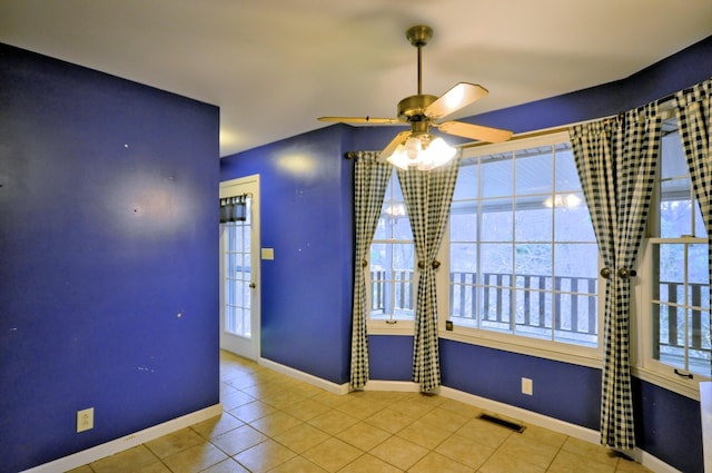 unfurnished room featuring tile patterned flooring, visible vents, and baseboards