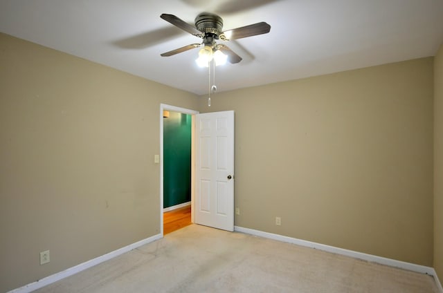 unfurnished room with ceiling fan, baseboards, and light colored carpet