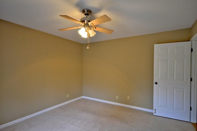 spare room with baseboards, a ceiling fan, and light colored carpet