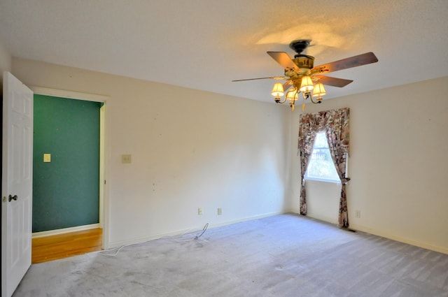 empty room with carpet floors, baseboards, and a ceiling fan