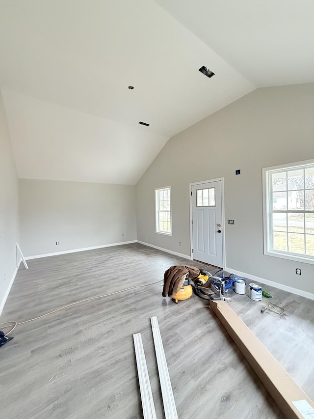 interior space featuring lofted ceiling, baseboards, and wood finished floors