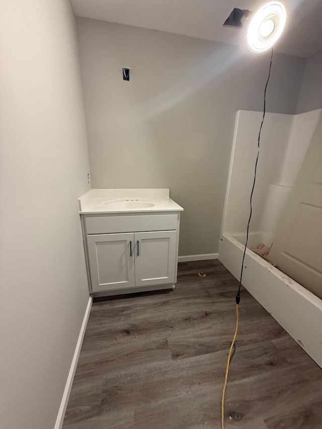 full bathroom with vanity, baseboards, and wood finished floors